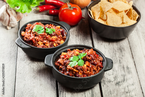 Bowls of hot chili con carne with ground beef, beans, tomatoes and corn