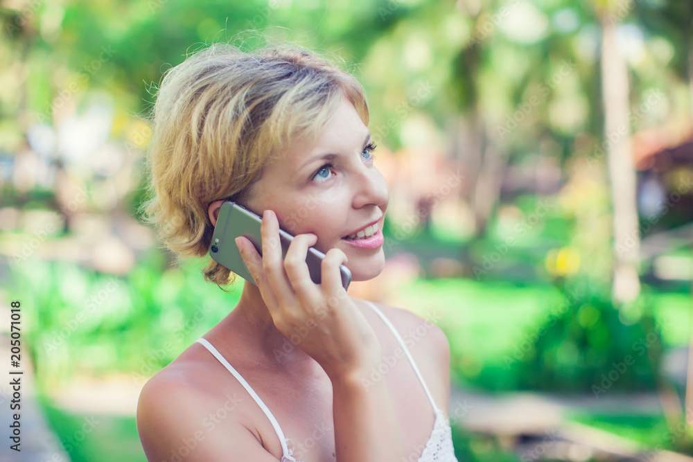 Portrait of a beautiful smiling woman using a mobile phone outdoors Portrait of a beautiful smiling woman using a mobile phone outdoors