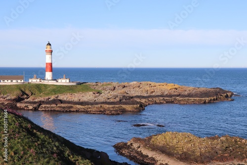 Red and white lighthouse on island © mcKensa