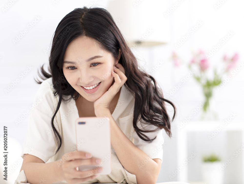 young woman sitting on couch and watching smart phone young woman sitting on couch and watching smart phone