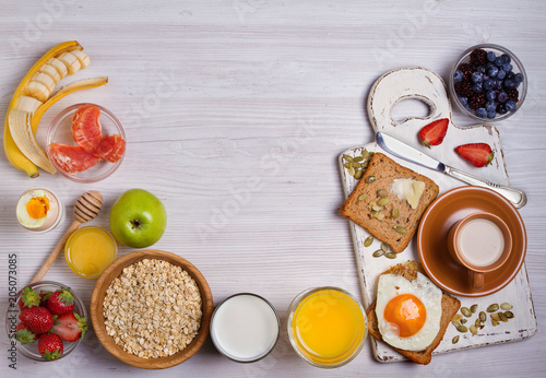 Breakfast served with coffee  orange juice  cereals  milk  fruits  eggs and toasts. Balance diet  food banner  background. View from above  top
