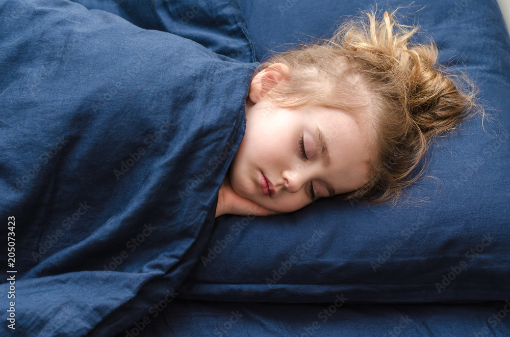 little pretty girl is sleeping soundly on blue bedding little pretty girl is sleeping soundly on blue bedding