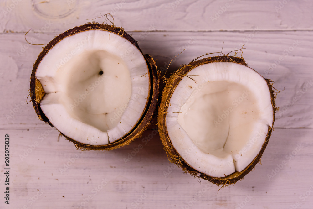 Ripe halved coconut on a wooden table. Top view Ripe halved coconut on a wooden table. Top view