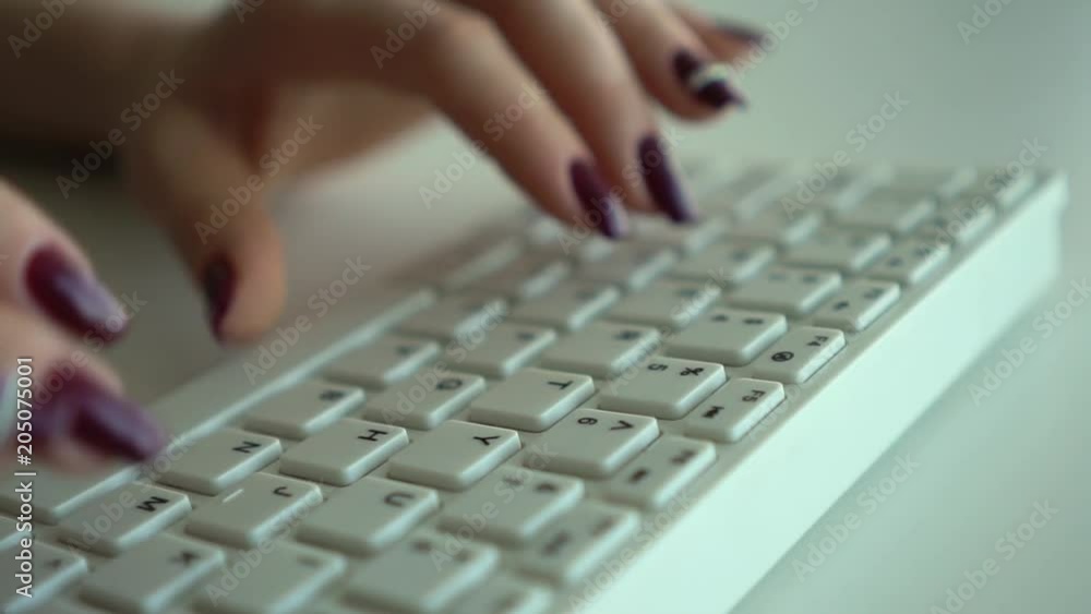 Female hands print information on the computer keyboard close-up. Slow motion