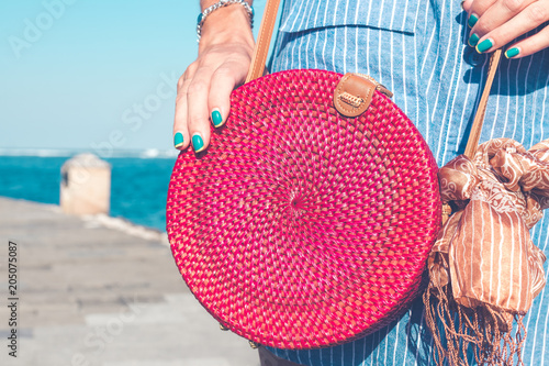 Woman with fashionable stylish rattan bag outside. Tropical island of Bali, Indonesia. Rattan and silk. photo