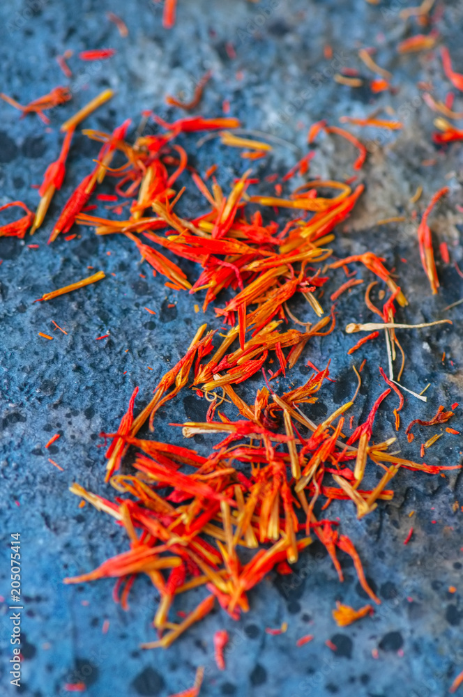 Fototapeta premium Dried saffron spice on a blue stone background.