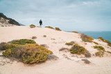 Ttraveler and photographer on the top of snow-white dune landscape on the Atlantic coastline. Sao Vicente, Cape verde