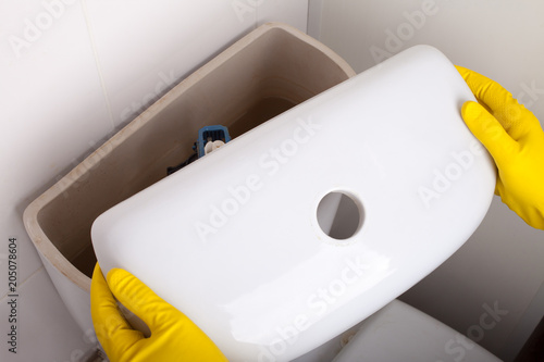 Bild auf Leinwand Plumber repairing toilet cistern at water closet, closeup