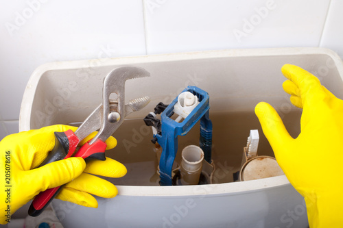 Bild auf Leinwand Plumber repairing toilet cistern at water closet, closeup