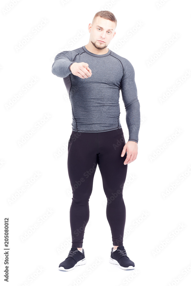 Portrait of handsome well-muscled gym instructor in sports tights and rashguard posing on white background Portrait of handsome well-muscled gym instructor in sports tights and rashguard posing on white background