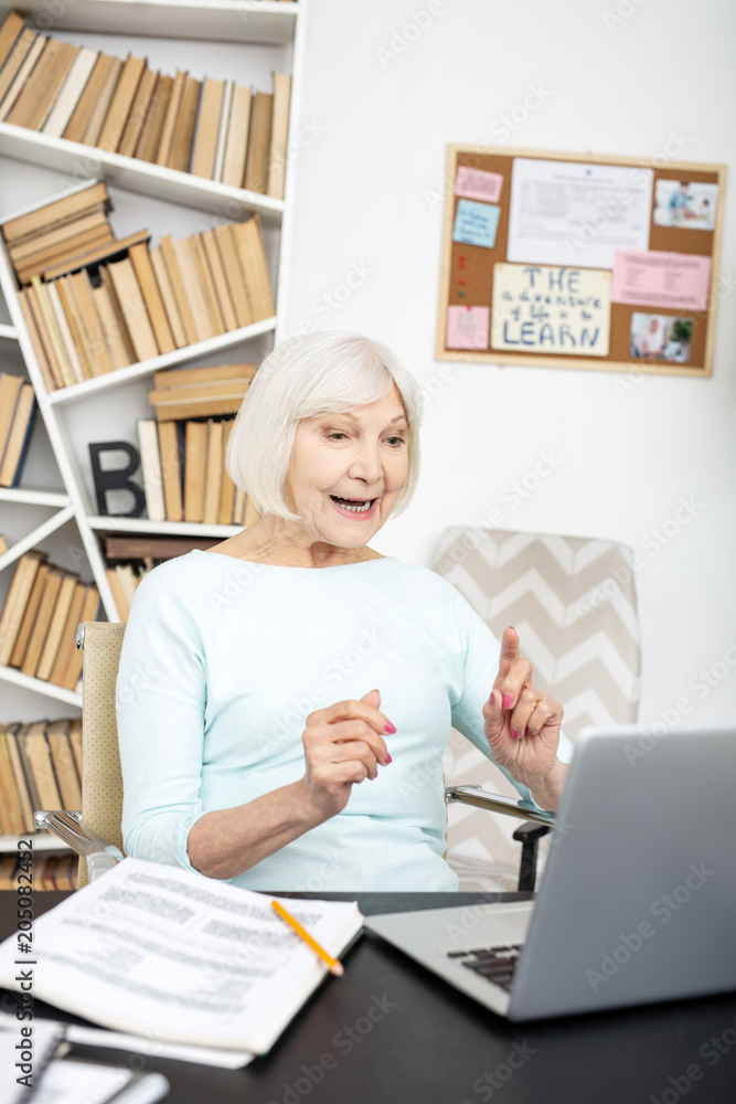 Ready to start. Enthusiastic senior freelancer using laptop while talking online Ready to start. Enthusiastic senior freelancer using laptop while talking online