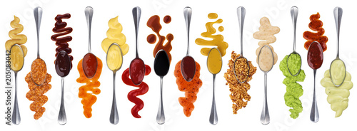 Set of different sauces with spoons isolated on white background