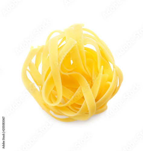 Uncooked fettuccine pasta on white background, top view