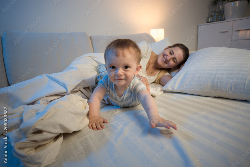 Cute smiling baby boy crawling on bed towards camera Cute smiling baby boy crawling on bed towards camera