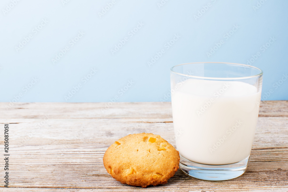 cookies and a glass of milk on a light table, on a blue background cookies and a glass of milk on a light table, on a blue background
