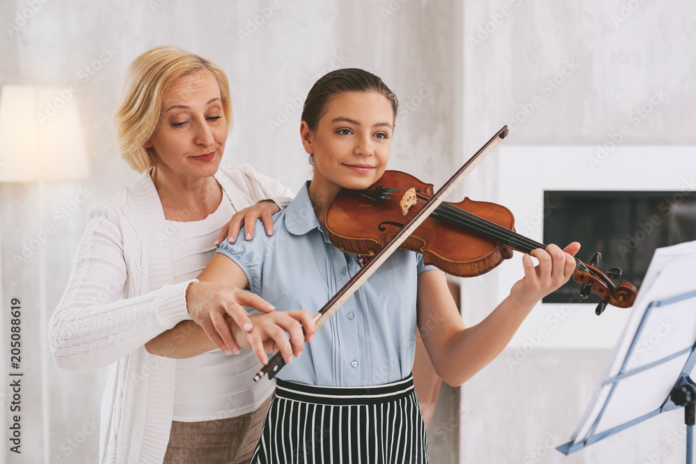Need your advice. Cheerful young female person holding violin while playing classical melody Need your advice. Cheerful young female person holding violin while playing classical melody