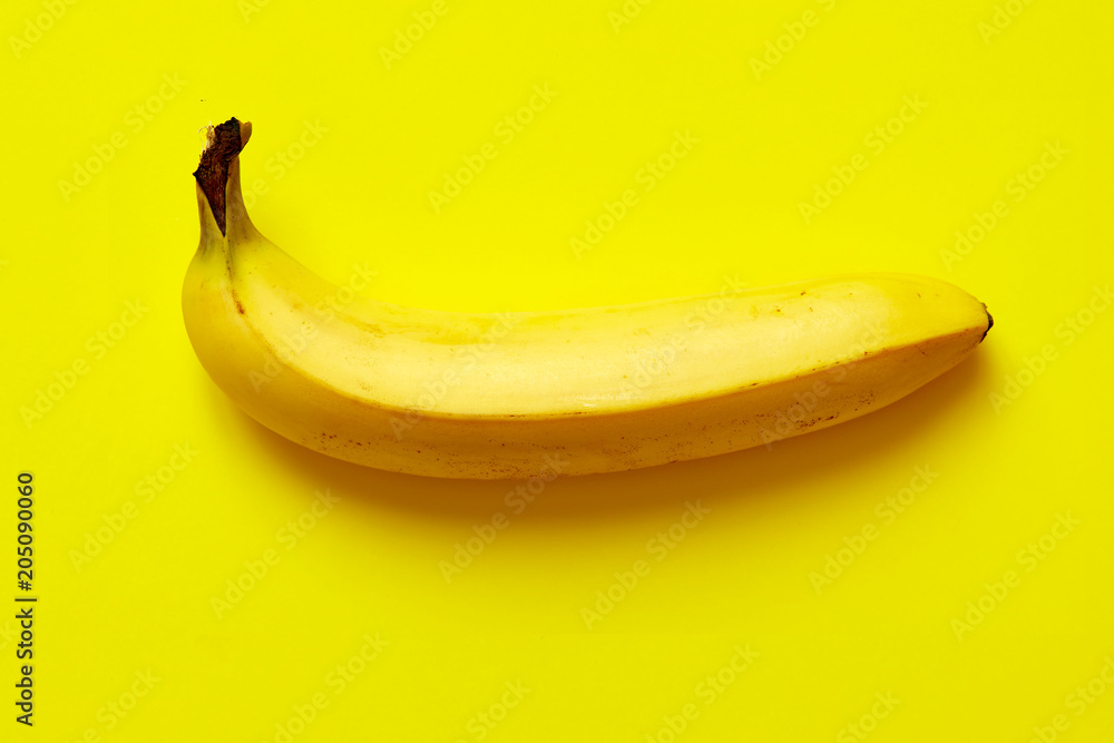 Close up of a ripe banana isolated on yellow background. Close up of a ripe banana isolated on yellow background.