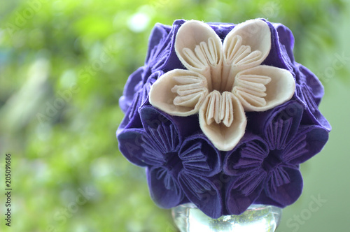 Purple and white origami kusudama flower on natural background