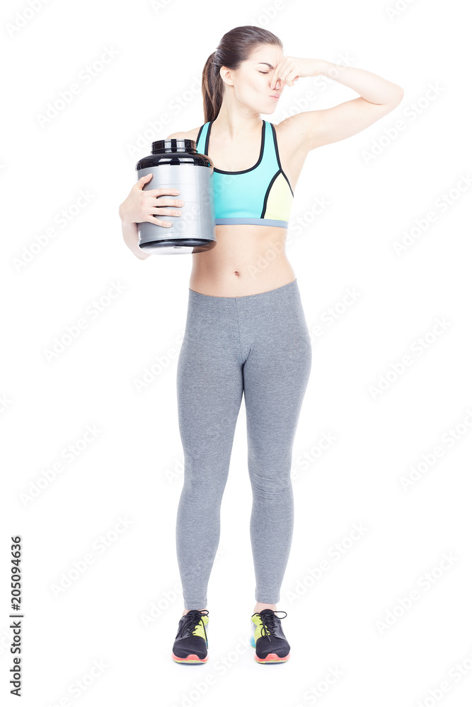 Portrait of slim female athlete holding container with sports nutrition isolated on white Portrait of slim female athlete holding container with sports nutrition isolated on white
