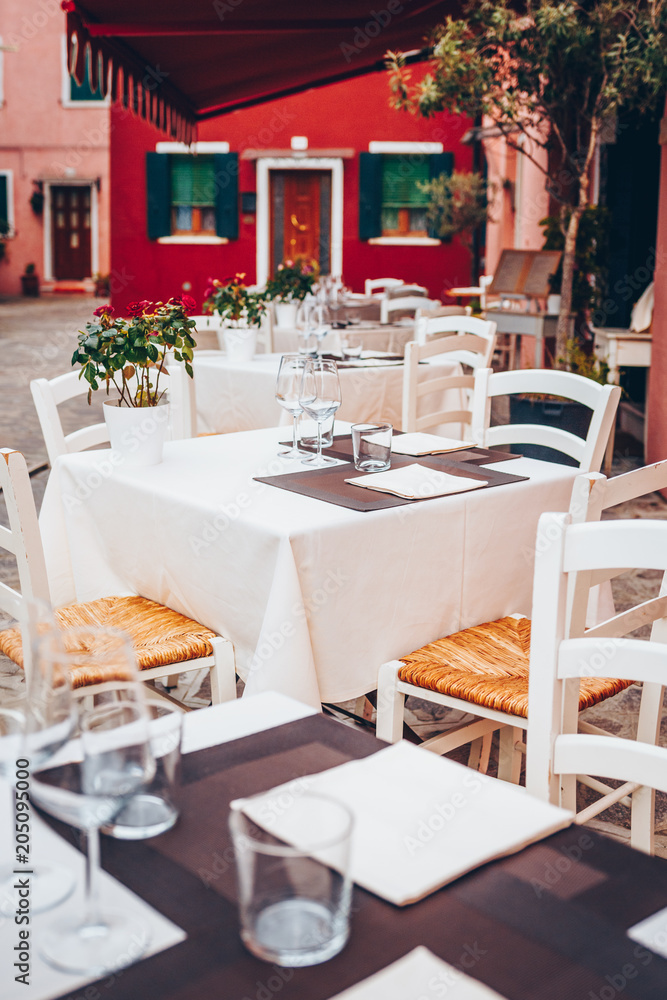 Table setting in Italian restourant, terrace. Wine glass, tablecloth Table setting in Italian restourant, terrace. Wine glass, tablecloth