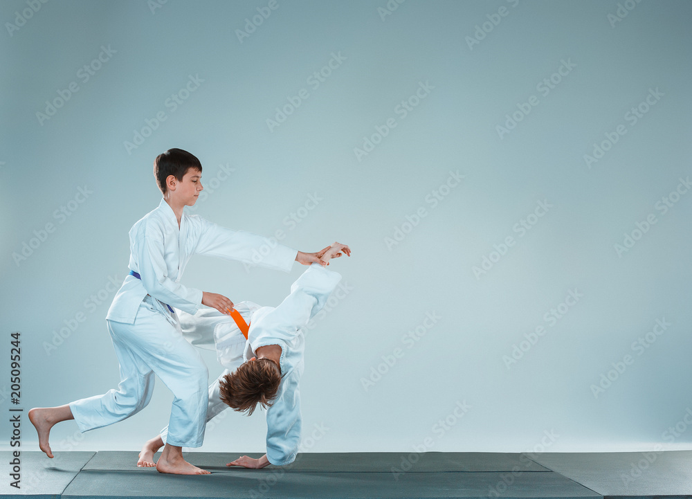 The two boys fighting at Aikido training in martial arts school. Healthy lifestyle and sports concept The two boys fighting at Aikido training in martial arts school. Healthy lifestyle and sports concept