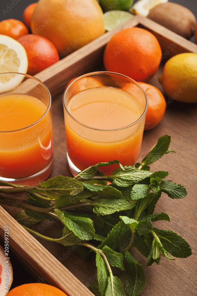 Heap of citruses and juice glasses on wood Heap of citruses and juice glasses on wood