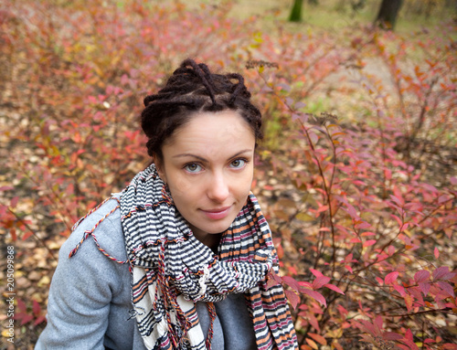 Pretty young woman with dreadlocks in autumn park