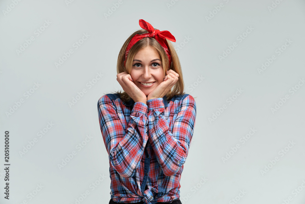 Studio portrait of a young woman in a plaid shirt and a bow on her head. Positive joyful cheerful emotions Studio portrait of a young woman in a plaid shirt and a bow on her head. Positive joyful cheerful emotions