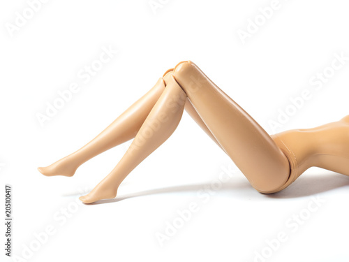 The beautiful slender legs of pretty figure girl doll doing gestures sexy isolated on white background