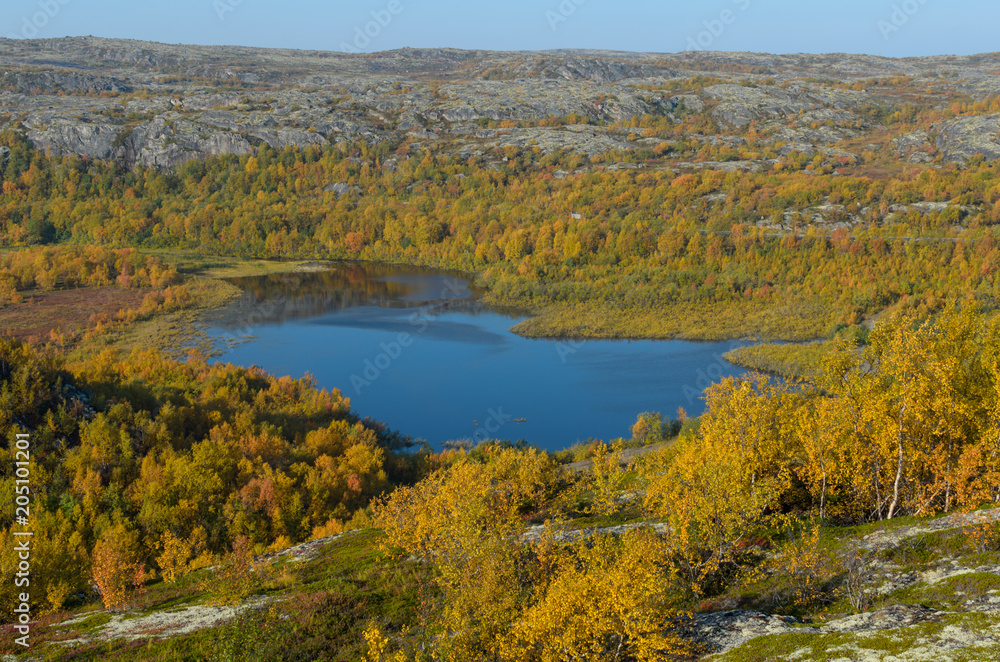 Top view of the lake and hills with forest in autumn.