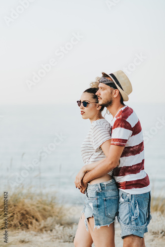  Young loving couple looking at sunset on the beach  © minastefanovic