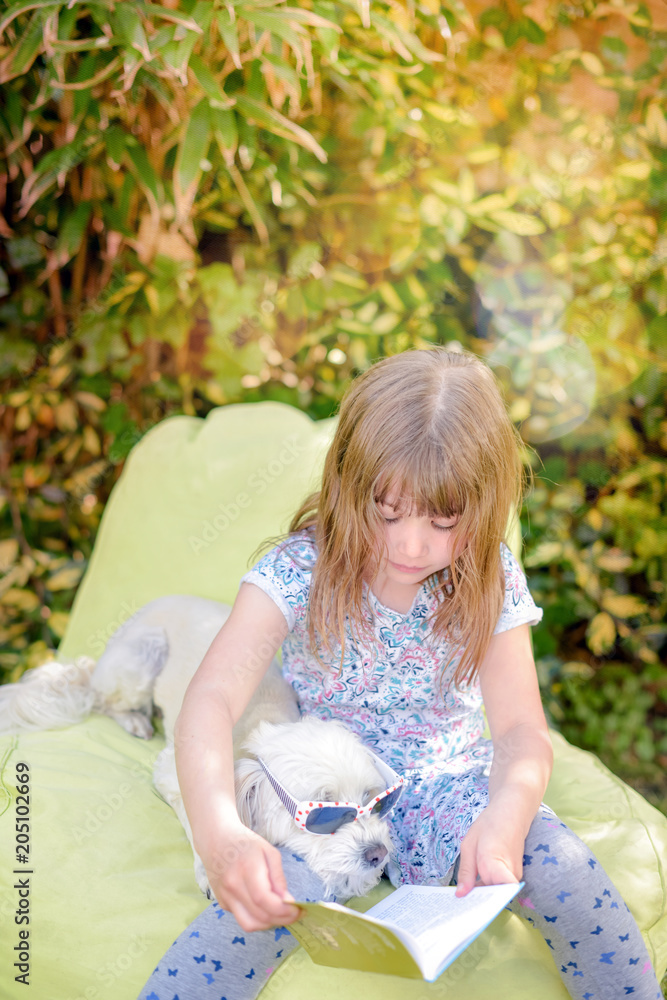 belle enfant lisant à l'ombre avec son chien belle enfant lisant à l'ombre avec son chien