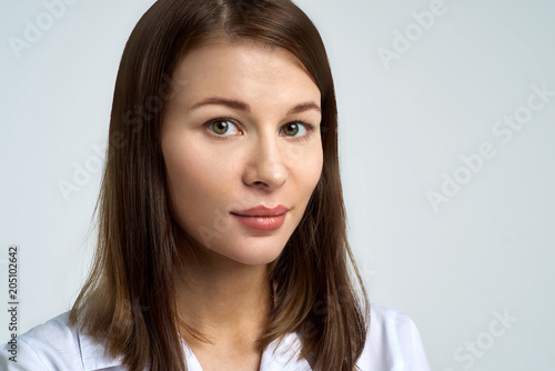 large facial portrait on isolated background of young beautiful white-skinned woman with dark hair.