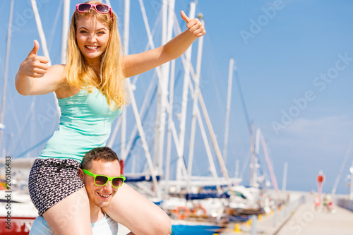 Man giving girlfriend piggyback ride on marina © Voyagerix