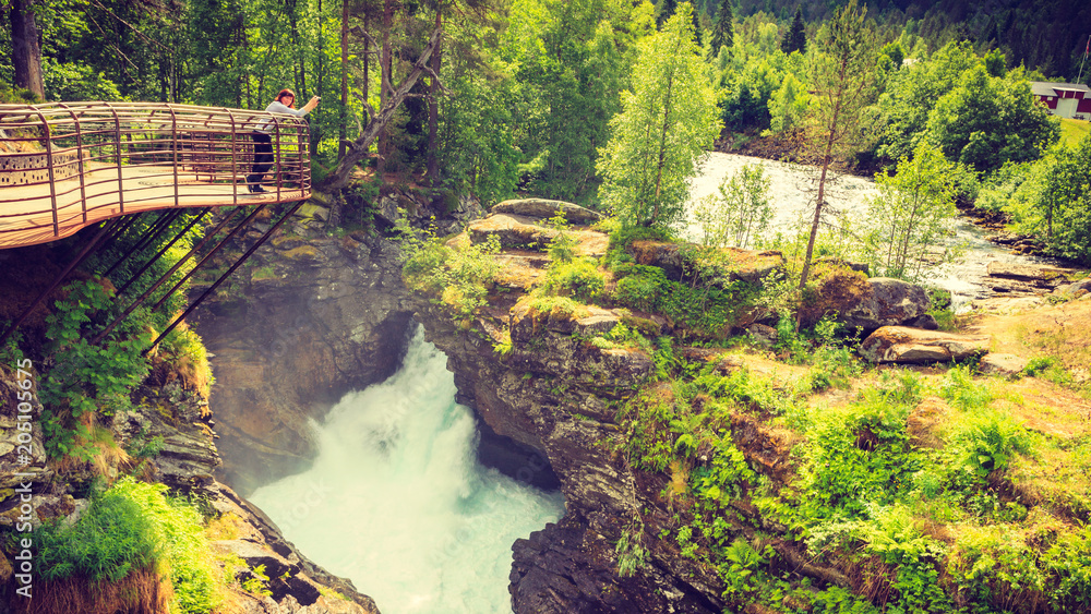 Tourist with camera on Gudbrandsjuvet waterfall, Norway