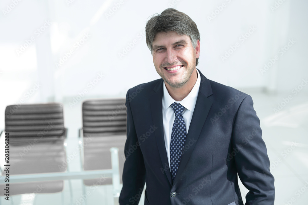 successful businessman standing by the desk. successful businessman standing by the desk.