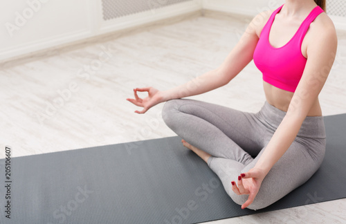 Woman training yoga in lotus pose, closeup