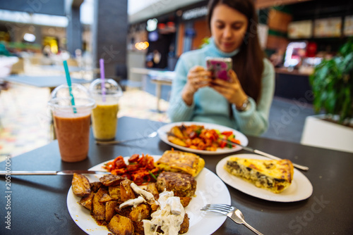 lunchtime in cafe. blurred woman on background into her phone. lifestyle.