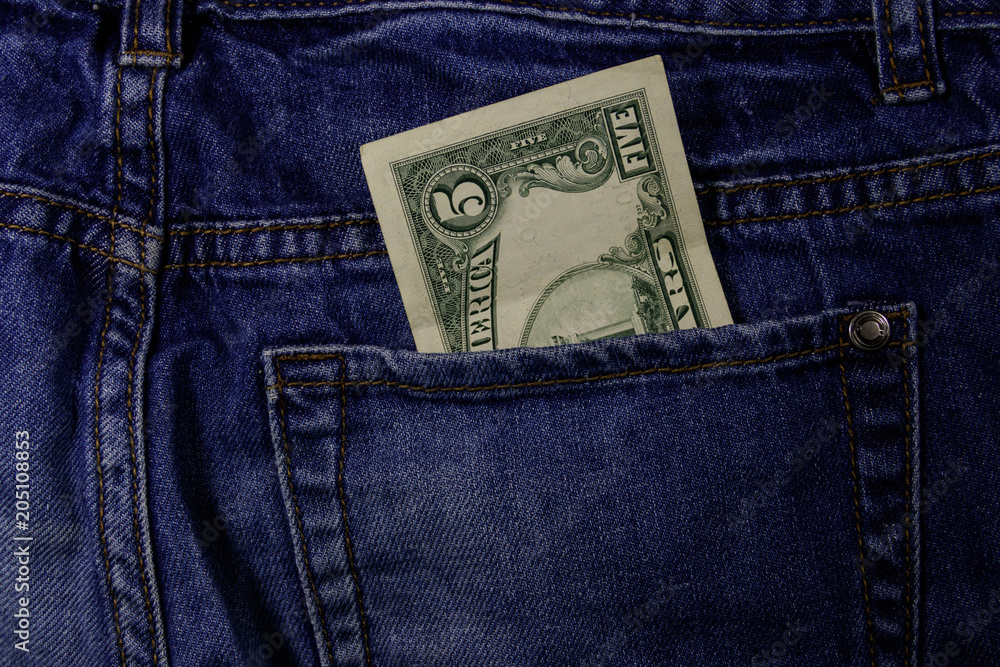 Five dollars banknote in the pocket of blue jeans Five dollars banknote in the pocket of blue jeans