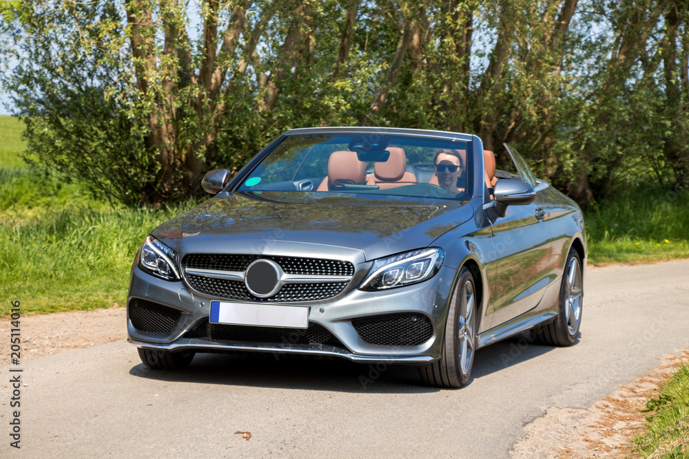 Young woman drive a convertible car on a sunny day Young woman drive a convertible car on a sunny day