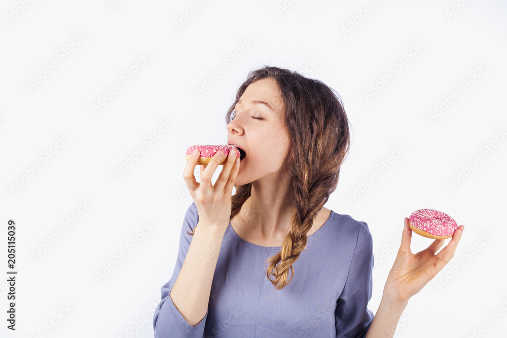 Young woman with us donut. The concept of harmful nutrition and diet Young woman with us donut. The concept of harmful nutrition and diet