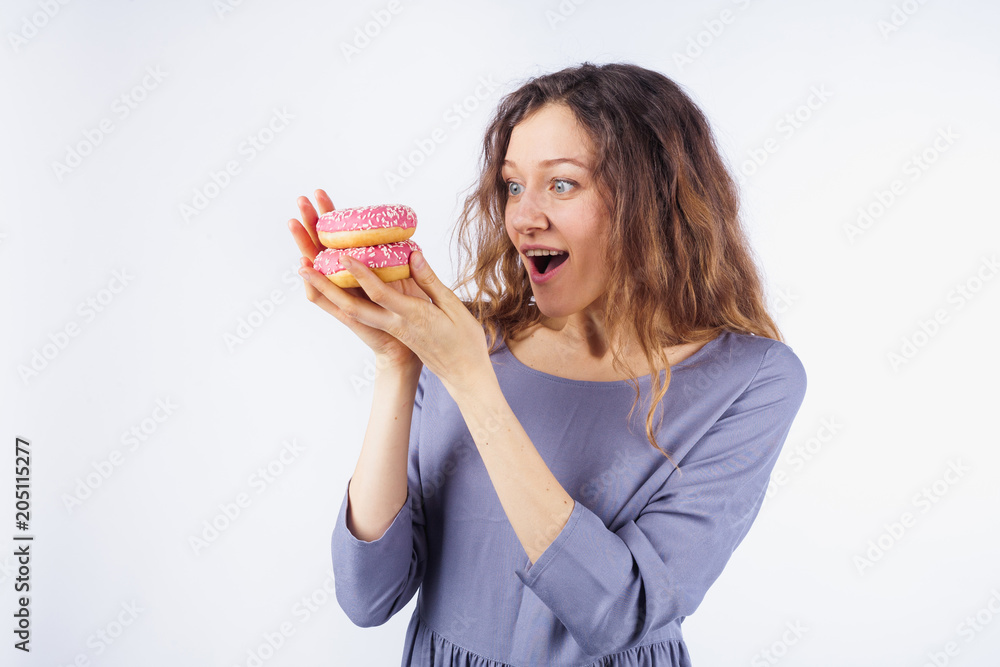 Young woman wants to eat donuts. The concept of diet and healthy nutrition Young woman wants to eat donuts. The concept of diet and healthy nutrition