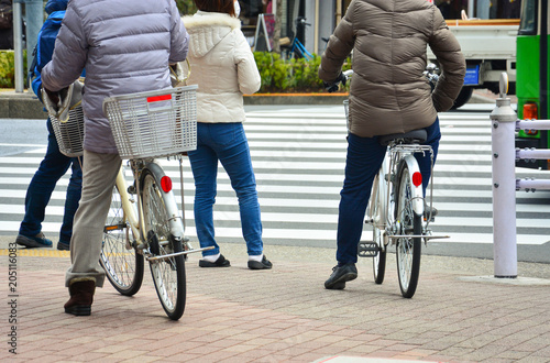 back side of man on vintage bicycle and pedestrian at the junction waiting for a signal to cross the road on the zebra crossing, urban lifestyle concept