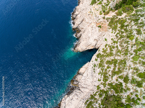 Aerial view of clear, turquoise blue water and rocky coast