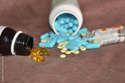 Blue medications are scattered from the cans for the treatment of diseases, the concept of health.