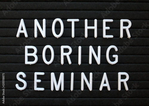 The words Another Boring Seminar in white plastic letters on a black letter board as a humorous reminder to provide content of interest to your audience