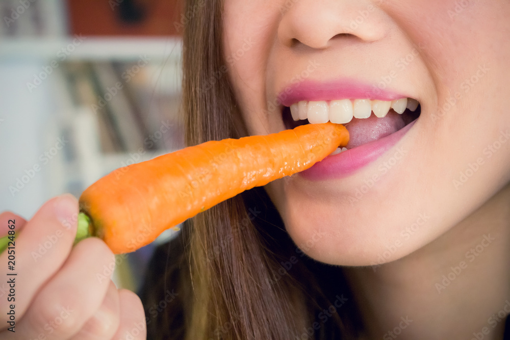 Happy woman bites carrot. Close up Happy woman bites carrot. Close up