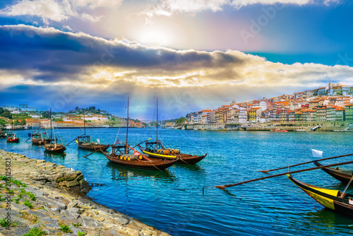 Cityscape over architecture and traditional boats on Rio Douro river in Porto city, Portugal