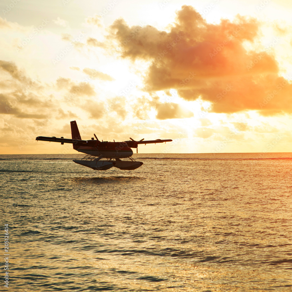 Summer sunrise with seaplane. Landing seaplane on the seashore. Calm scenery on morning sea. Summer sunrise with seaplane. Landing seaplane on the seashore. Calm scenery on morning sea.
