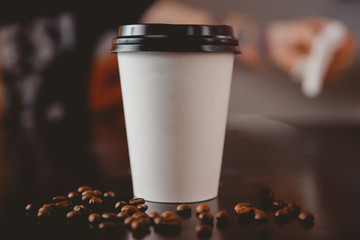 Küchenrückwand glas motiv Kaffee und Kaffeebohnen Auf dem Tisch liegen weiße Pappbecher Kaffee mit schwarzen Kappen in den vorderen Körnern. Konzept der Essenslieferung  © Parilov